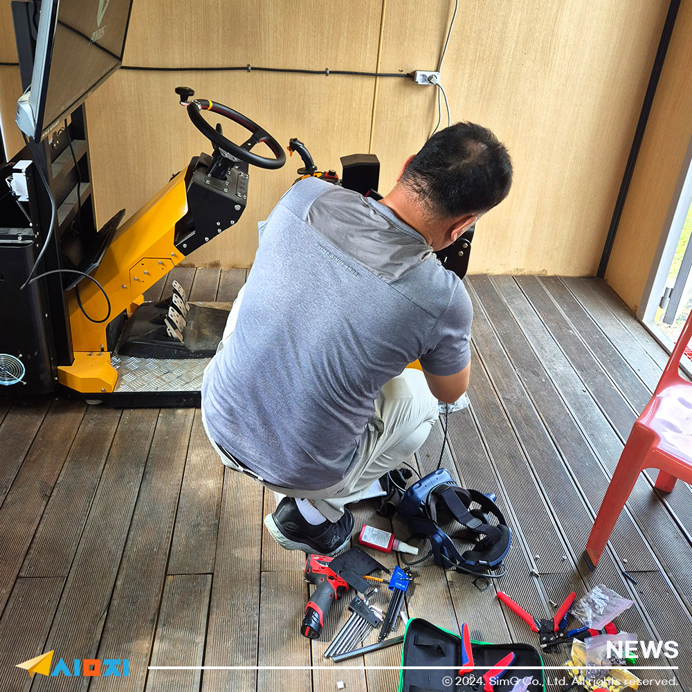 전문 설치팀이 굴착기 시뮬레이터를 설치하고 있는 사진