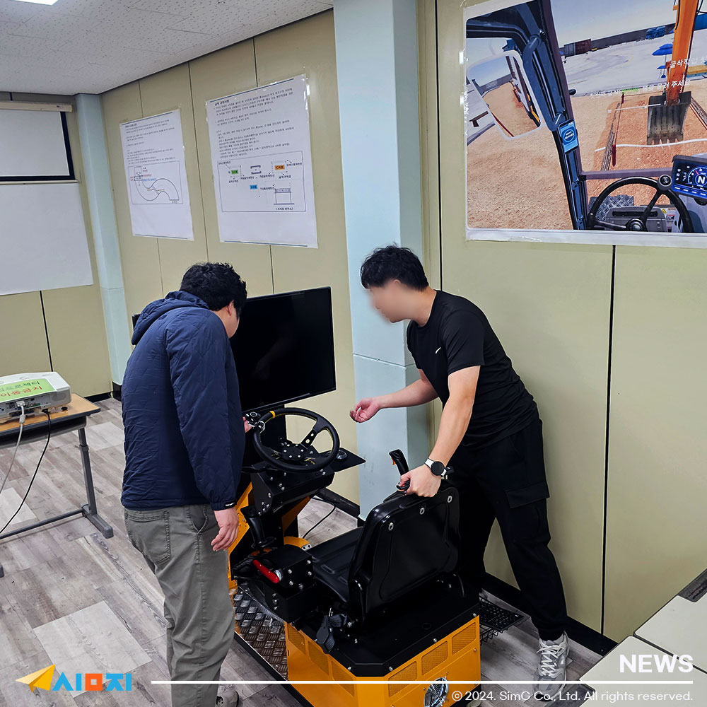 굴착기 시뮬레이터에 대해 설명해주고 있는 사진