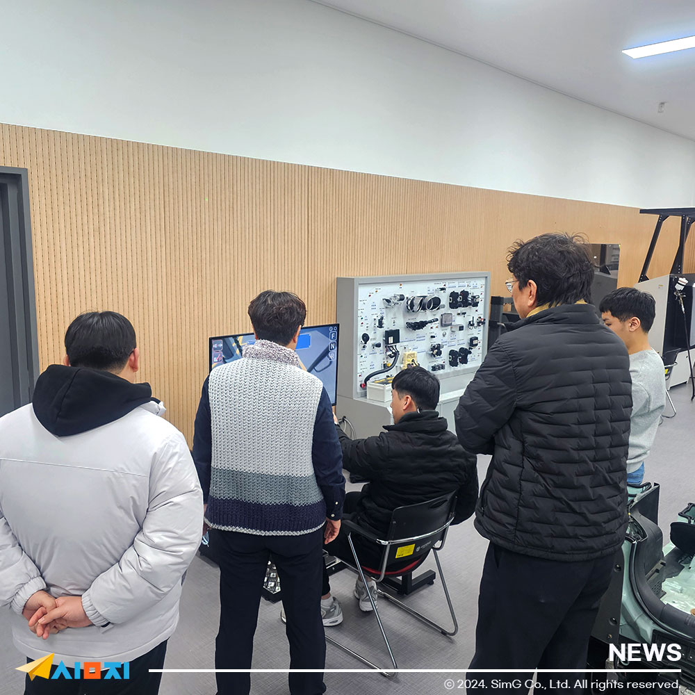 학생들이 지게차 시뮬레이터를 시연해보고 있는 사진